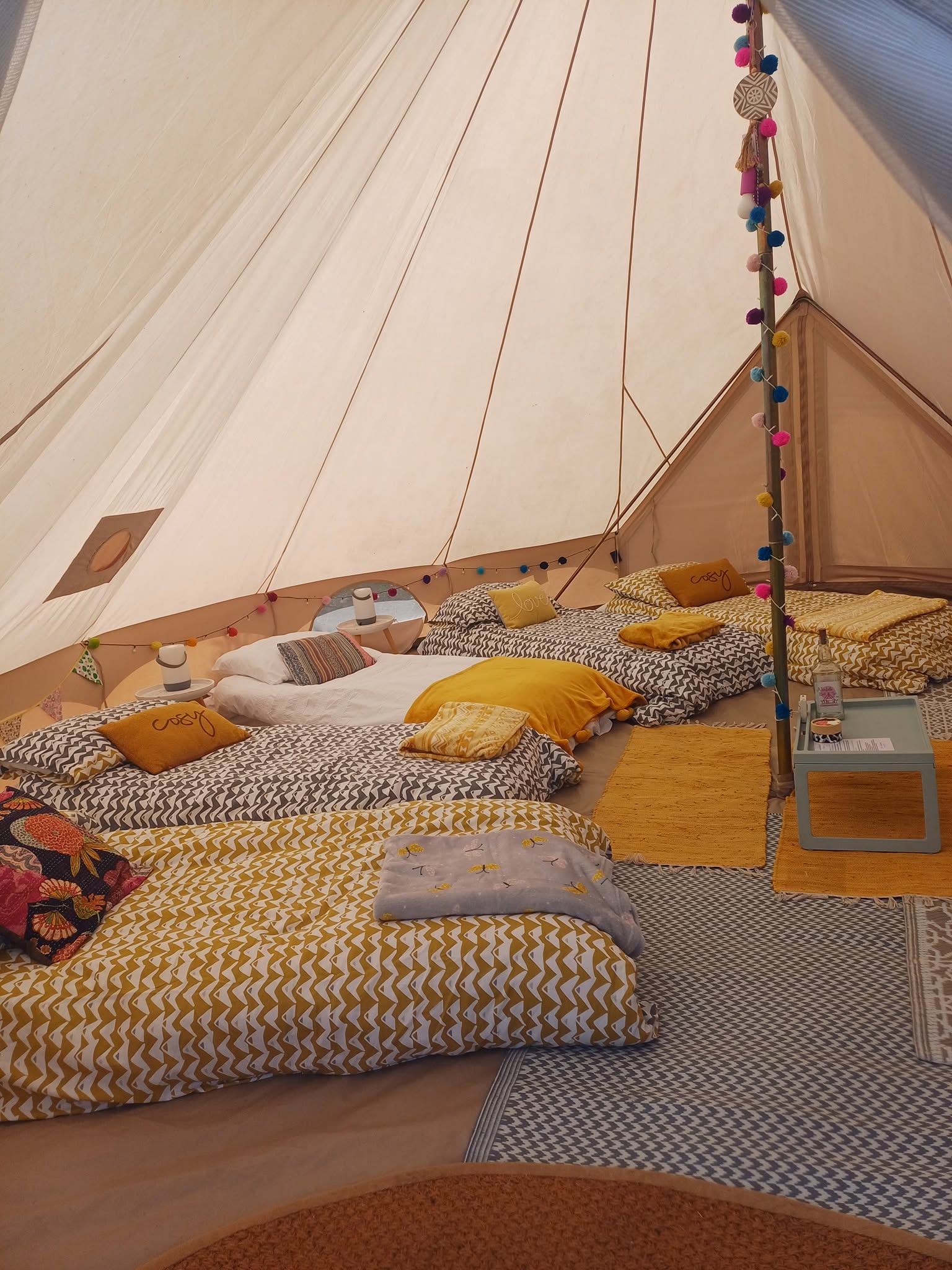 Bell tent interior with cushions and bedding